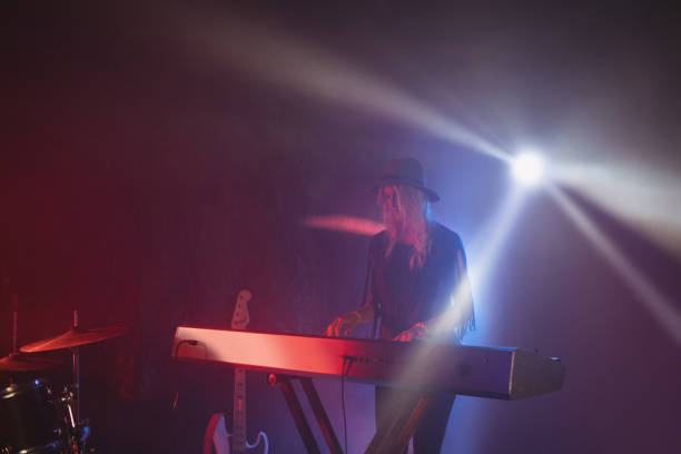 istock Female performer playing piano on illuminated stage 802990630