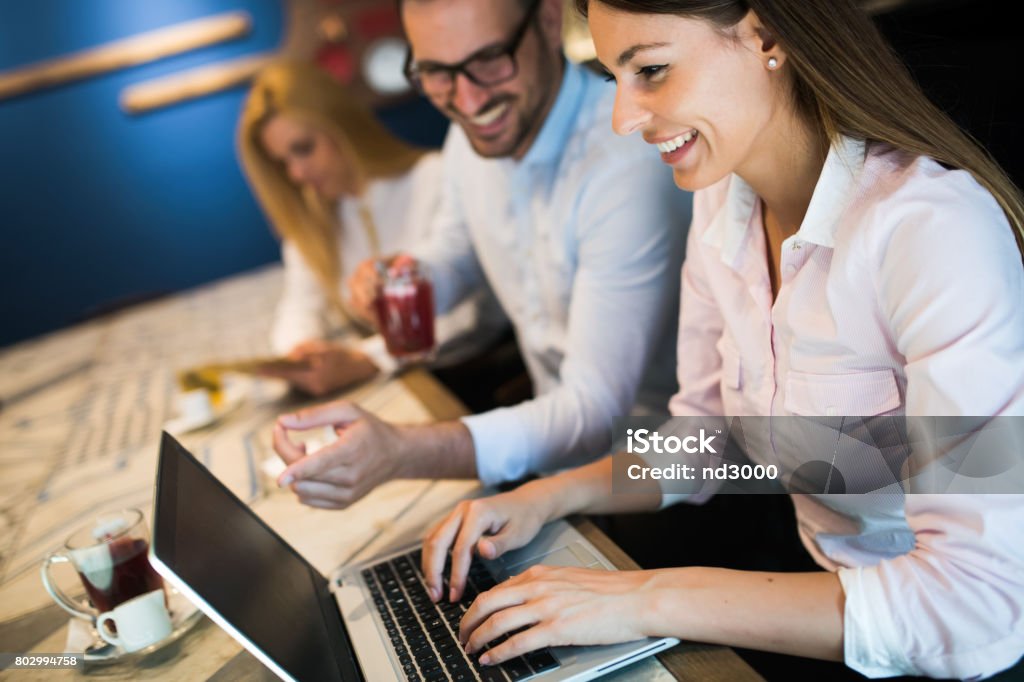 Drie jonge glimlachend collega's samen te werken op de laptop - Royalty-free Advies Stockfoto Drie jonge glimlachend collega's samen te werken op de laptop - Royalty-free Advies Stockfoto