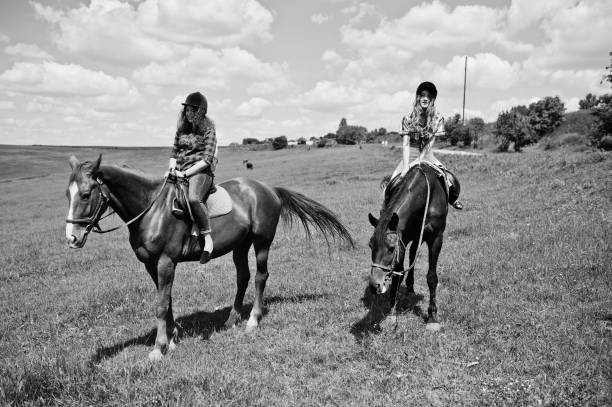 jeunes de remorquage jolie filles un cheval sur un champ à une journée ensoleillée. - bride women standing beauty in nature photos et images de collection