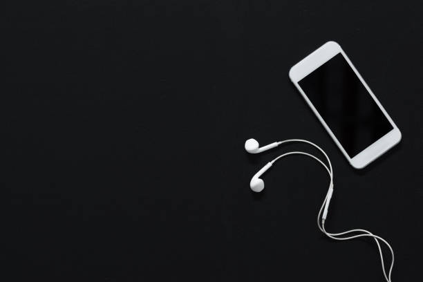 modern smartphone with blank screen and earphones isolated on black