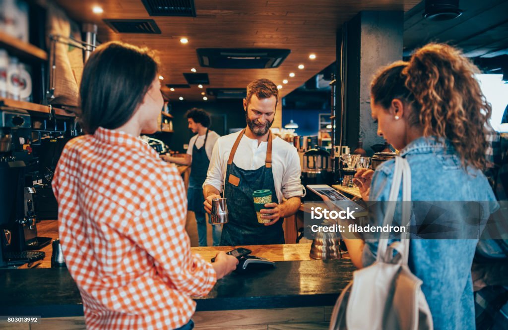 Customer paying while getting her order Customer making a contactless payment via smart phone at a cafeteria. Coffee - Drink Stock Photo