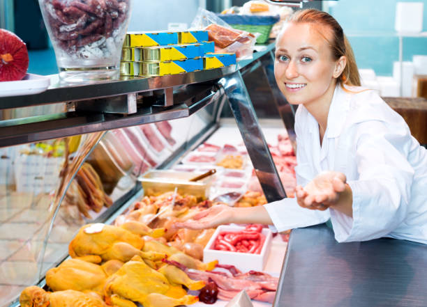 istock Female seller wearing uniform working with fresh meat 803014872
