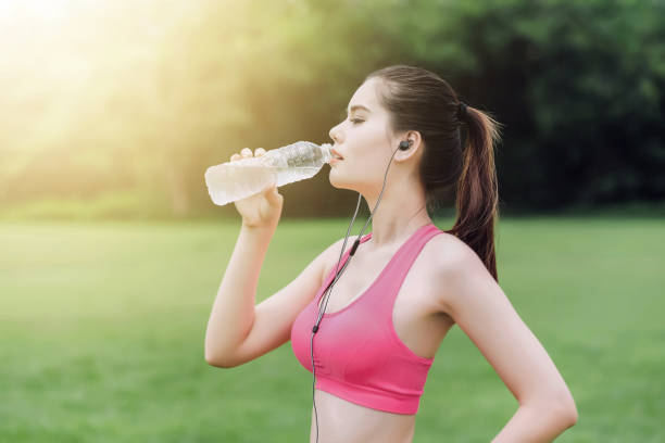istock Young girl drinking water resting after exercise in nature park 803021258
