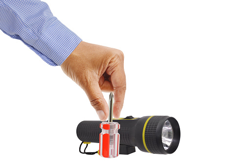 hand placing screwdriver in front of flashlight isolated on white background