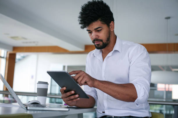istock African American business man using digital tablet at the office. African man working on tablet. 803045394