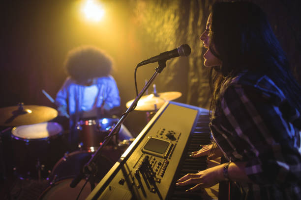 istock Female playing piano while performing in nightclub 803050534