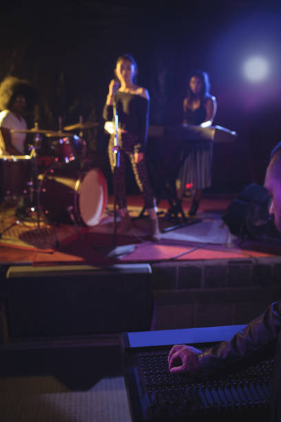 istock Musicians and singer performing on illuminated stage in nightclub 803054842