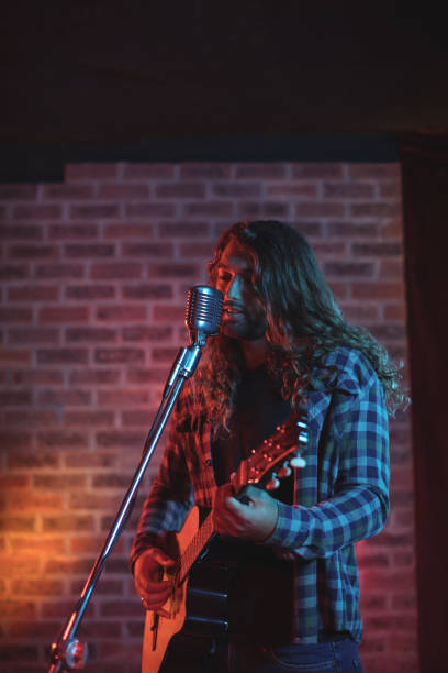 istock Male singer performing on stage in nightclub 803057466