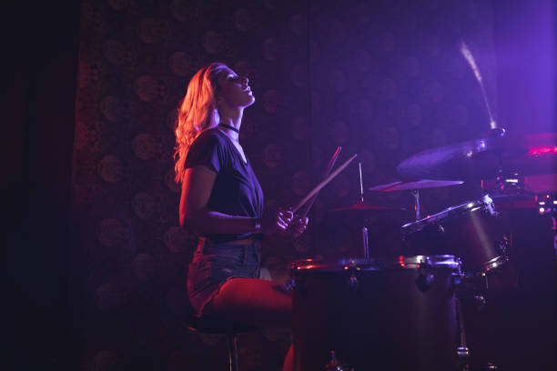 istock Young female drummer performing in illuminated nightclub 803057838