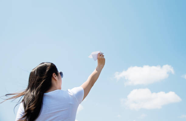 istock Woman throwing a paper airplane 803057978