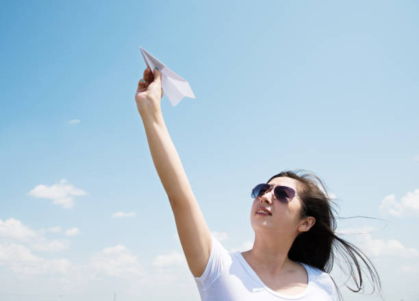 istock Woman throwing a paper airplane 803060126