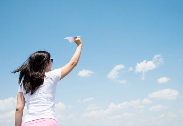 istock Woman throwing a paper airplane 803061296