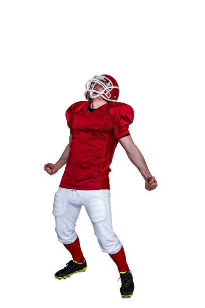 A triumph of an american football player A triumph of an american football player with black background american football player studio stock pictures, royalty-free photos & images