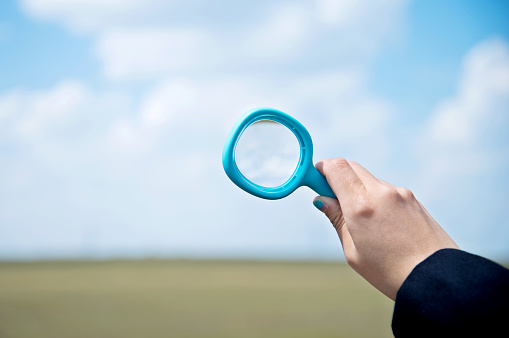 Man holds a magnifying glass between his fingers