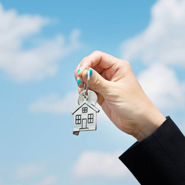 istock Woman hand holding a house key 803068298