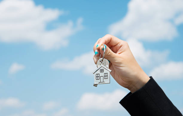 istock Woman hand holding a house key 803068428