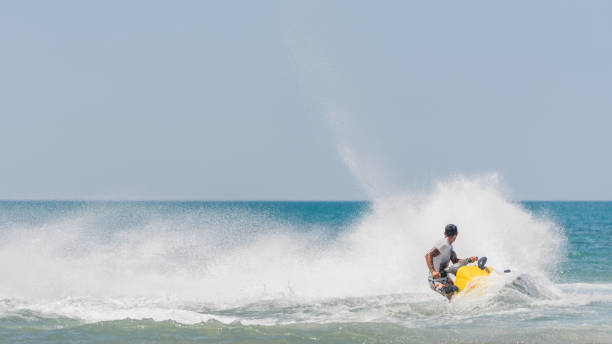 młodzi mężczyźni przelatujący po morzu karaibskim na skuterze wodnym - wake jet boat water water sport zdjęcia i obrazy z banku zdjęć