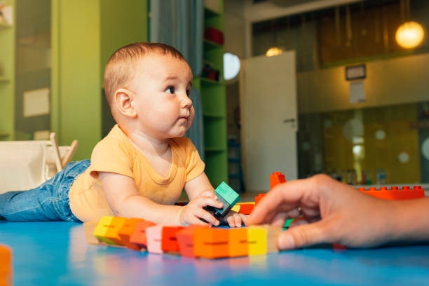 istock Happy baby playing with toy blocks. 803077888