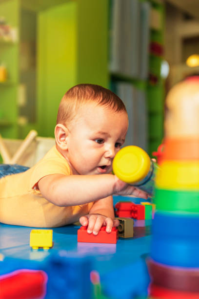 istock Happy baby playing with toy blocks in the kindergarten. 803082166