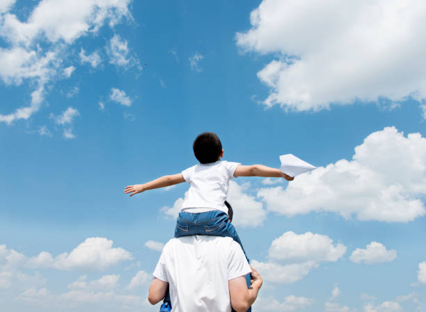 istock Son and father play paper airplane 803102012