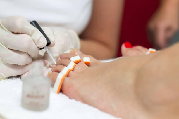 istock Carefully applying polish on customer's nails on her feet 803105490