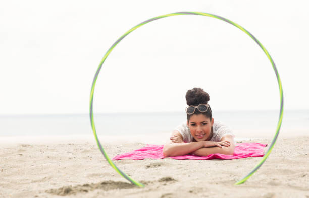 istock Smiling woman looking at camera through hula hoop 803105580