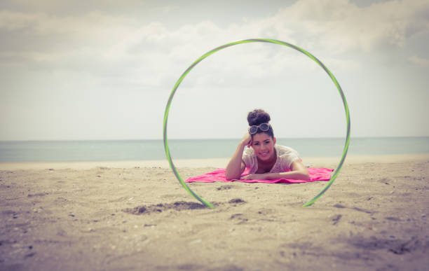 istock Smiling woman looking at camera through hula hoop 803105638