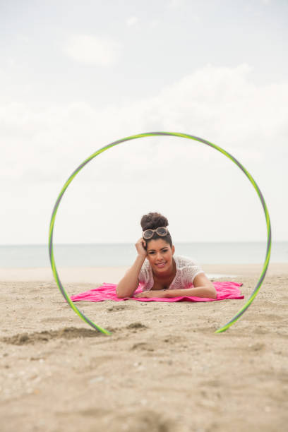 istock Smiling woman looking at camera through hula hoop 803105668