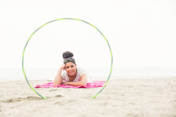istock Smiling woman looking at camera through hula hoop 803105696