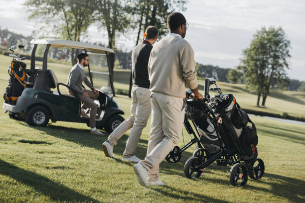 joueurs de golf multiethnique avec des sacs de golf et voiturette de golf, passer du temps ensemble - golf cart golf mode of transport transportation photos et images de collection