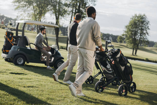 istock multiethnic golf players with golf bags and golf cart spending time together 803113276