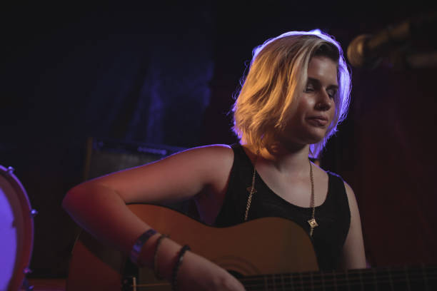 istock Female playing guitar in nightclub 803113378