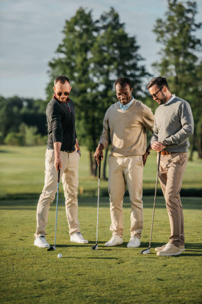 istock stylish multiethnic friends spending time together while playing golf on golf course 803113830