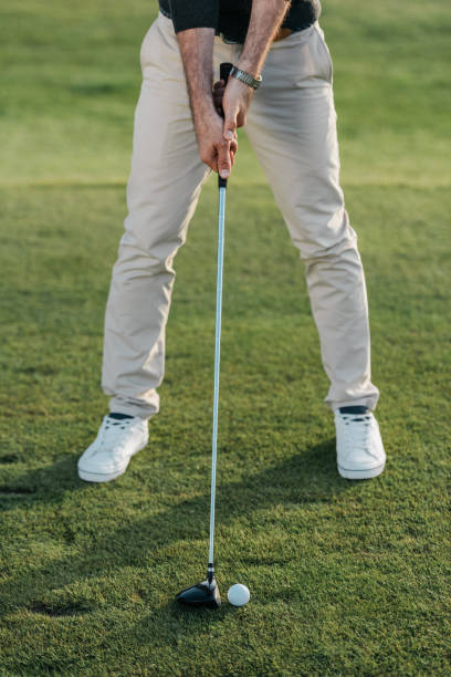 istock cropped view of stylish man playing golf on golf course at daytime 803113904