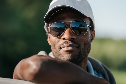 Close-up portrait of handsome african american man in cap and sunglasses
