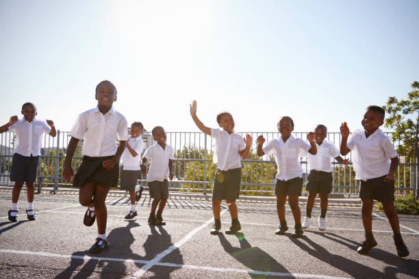 la escuela primaria los niños divirtiéndose en el patio de la escuela - africa african descent education child fotografías e imágenes de stock