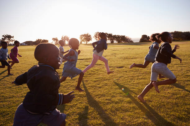 istock Elementary school boys and girls running in an open field 803138280