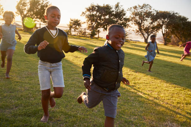 istock Elementary school kids running to camera in an open field 803138360