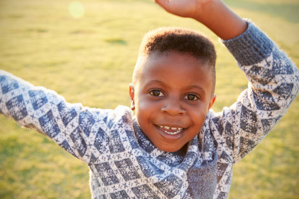 istock African elementary school boy waving to camera outdoors 803138524