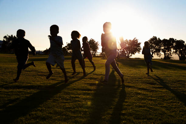istock Silhouetted elementary school kids running in a field 803138636