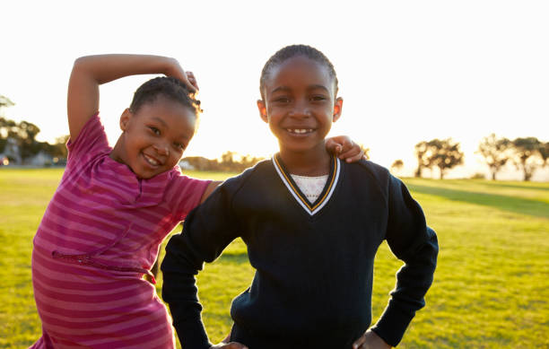 istock Two African elementary schoolgirls pose to camera in a field 803138706