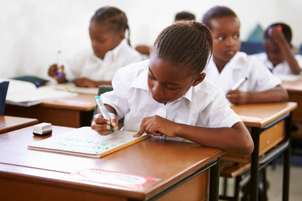 istock Schoolgirl writing at her desk in elementary school lesson 803149712