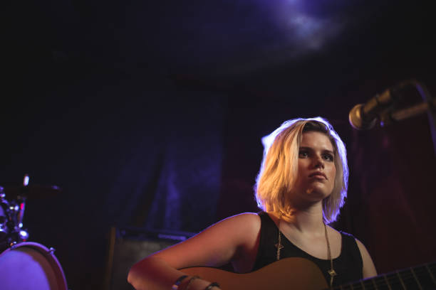 istock Female playing guitar in nightclub 803162300