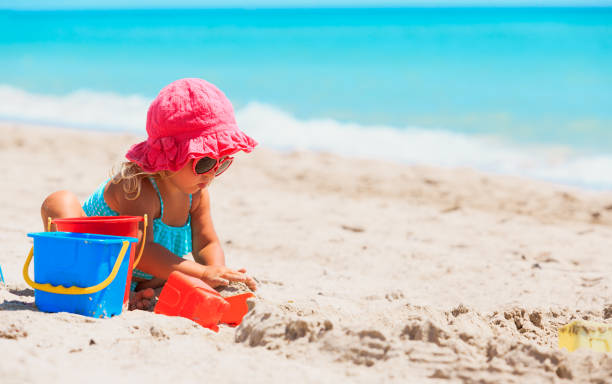 istock cute little girl play with sand on beach 803171880