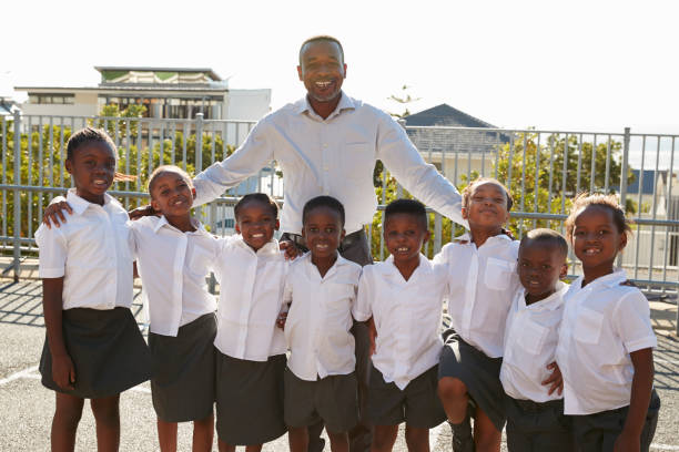istock Teacher and elementary school kids in playground, portrait 803172394