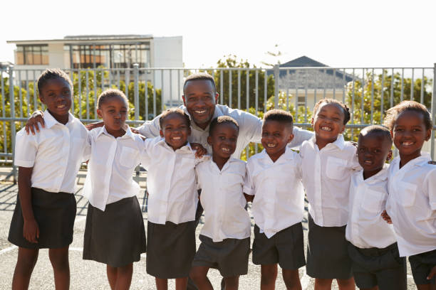 istock Teacher and elementary school kids in playground, portrait 803172442