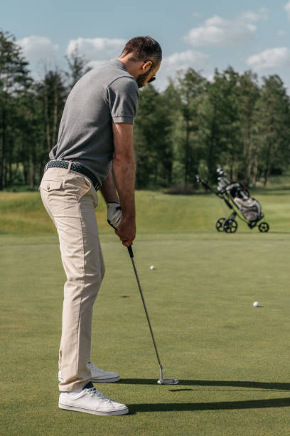 istock young casual man playing golf on green at daytime 803184432