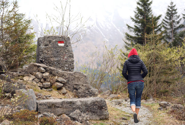 istock young woman with red hood walks on mountain path 803185934
