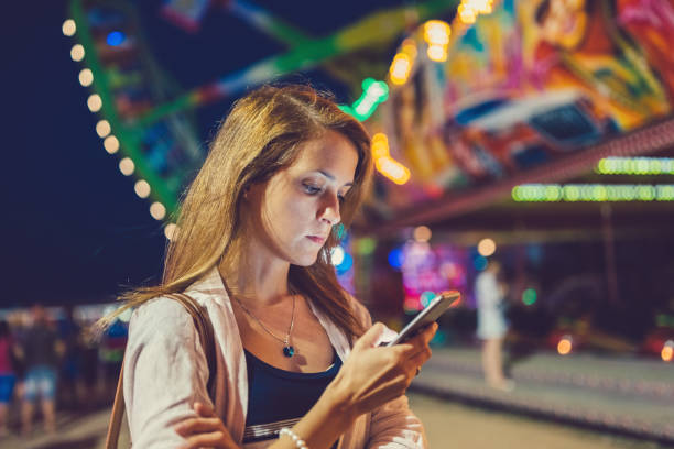 istock Confused girl at the amusement park using smartphone 803188510