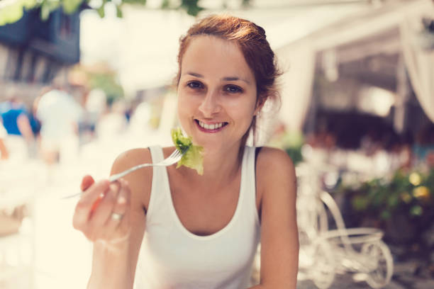 istock Smiling woman in restaurant eating fresh salad 803193084